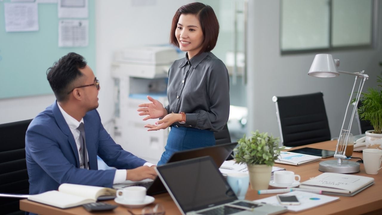 a woman and a man talking in office